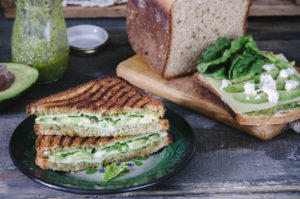 Healthy sandwich with cheese, pesto, avocado and spinach